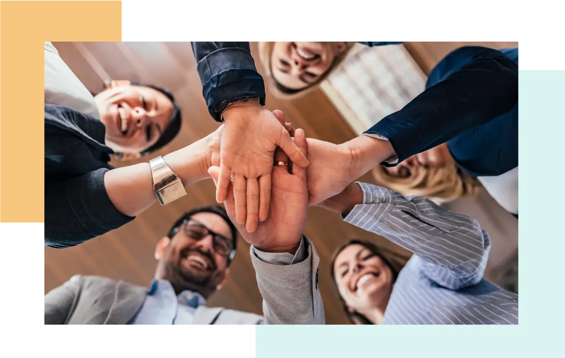 A diverse group placing their hands together